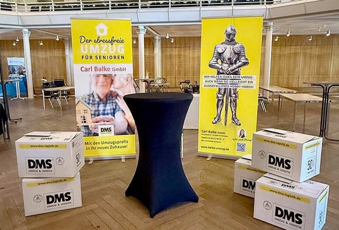 Messestand von Carl Balke mit Tisch und Kartons
