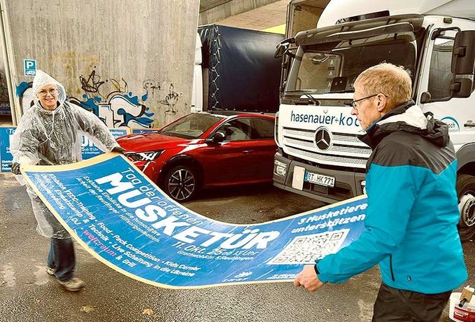 Zwei Personen mit Plakat in den Händen