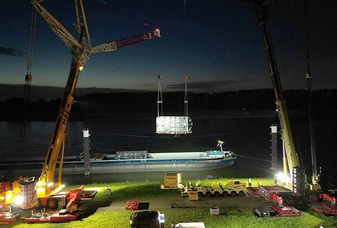 Nachtaufnahme: Kräne heben Filteranlage vom Schiff