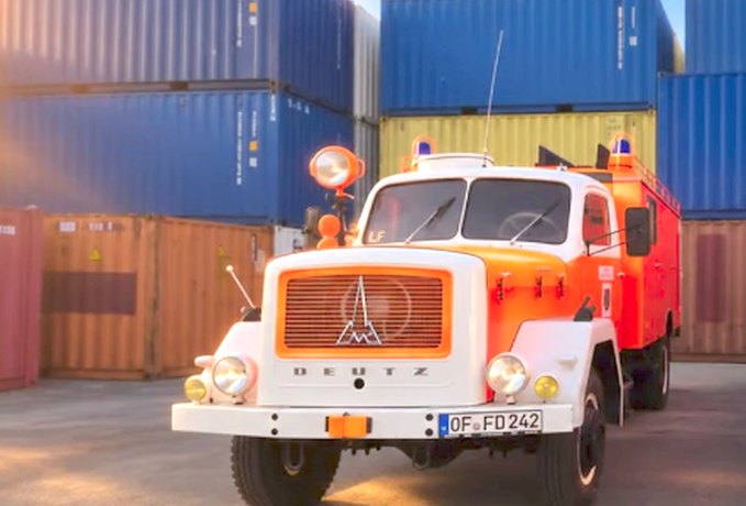 Feuerwehrfahrzeug vor Containern