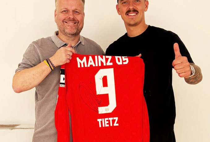 Phillip Tietz mit Mainz-05-Trikot und Mitarbeiter von DMS Höhne-Grass