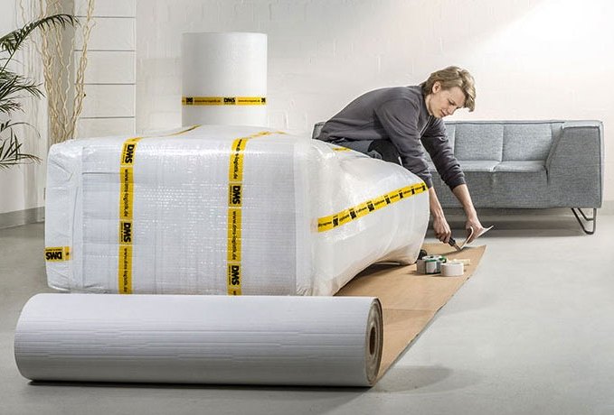 DMS-Mitarbeiterin verpackt ein Sofa für den Transport